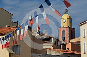 Famous church in St. Tropez with a row of French flags