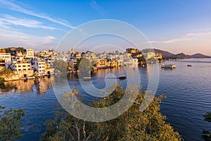 The famous city palace on Lake Pichola reflecting sunset light. Udaipur, travel destination and tourist attraction in Rajasthan, I