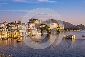 The famous city palace on Lake Pichola reflecting sunset light. Udaipur, travel destination and tourist attraction in Rajasthan, I