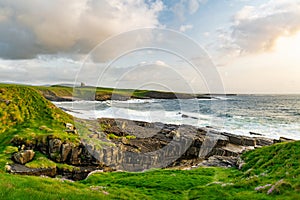 Famous Classiebawn Castle in picturesque landscape of Mullaghmore Head. Spectacular sunset view with waves rolling ashore.