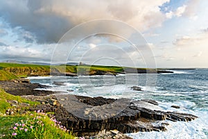 Famous Classiebawn Castle in picturesque landscape of Mullaghmore Head. Spectacular sunset view with waves rolling ashore.