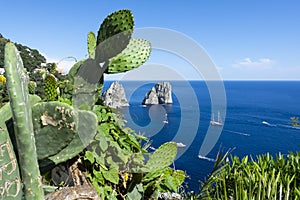 The famous Faraglioni rocks from Capri island, Italy. Sunny summer weather with blue sky and white clouds.