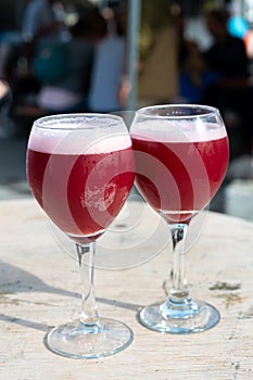 Famous fresh brewed red lambic kriek cherry beer served outside in Belgian beer festival in Durbuy, special Belgian beer glass in photo