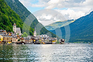 Famous Hallstatt city panorama with typical church near the Hallstatter see. Dramatic clouds on the sky. Famous tourist