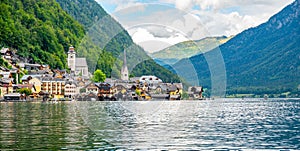 Famous Hallstatt city panorama with typical church near the Hallstatter see. Dramatic clouds on the sky. Famous tourist