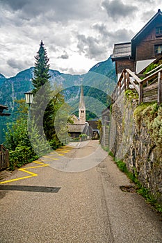 Famous Hallstatt city panorama with typical church near the Hallstatter see. Dramatic clouds on the sky. Famous tourist