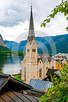 Famous Hallstatt city panorama with typical church near the Hallstatter see. Dramatic clouds on the sky. Famous tourist