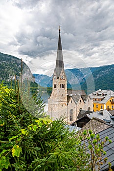 Famous Hallstatt city panorama with typical church near the Hallstatter see. Dramatic clouds on the sky. Famous tourist