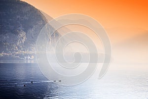 The famous Hallstatt lake - the moment of sunrise in a autumn foggy morning.