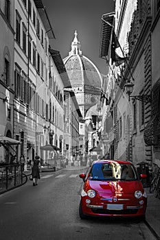 Famous historic red car in Florence street. Color in black and white. Old charming auto concept.