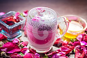 Famous Indian & Asian Summer and Ramadan drink i.e. Gulab shake or Rose falooda in a glass on wooden surface.