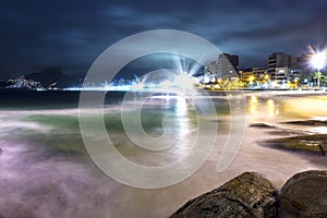Famous Ipanema Beach At Night With Beautiful Lights And Slow Water Waves Over Rocks
