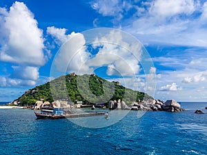 Scenic view tropical paradise with peaceful resort, rocky coastline, clear turquoise sea with coral reef against cloud sky. Koh