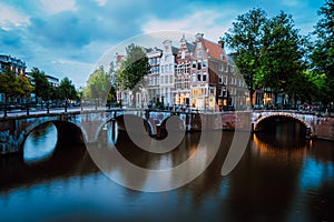 Famous Keizersgracht Emperor`s canal in Amsterdam, dutch scenery with illuminated bridge at twilight, Netherlands