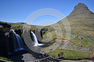 Famous kirkjufell mountain with the kirkjufell falls waterfalls in front in GrundarfjÃ¶dur in Iceland