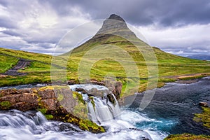 Famous Kirkjufellsfoss waterfall with Kirkjufell church mountain on the background, beautiful landscape, Iceland