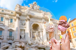 Famous landmark fountain di Trevi in Rome, Italy during summer sunny day with italian ice cream gelato in the foreground