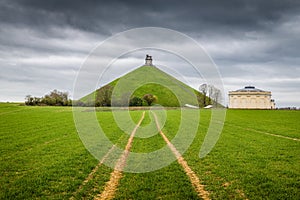 Famous Lion`s Mound memorial site at the battlefield of Waterloo with dark clouds, Belgium