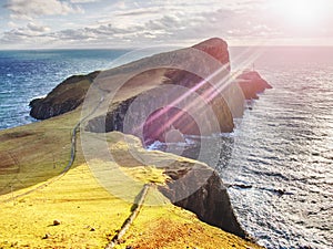 Famous look at Lighthouse on the cliff of Neist Point, rocky coast on the Isle of Skye