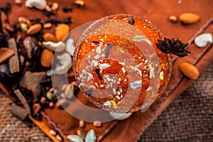 Famous mango preservation i.e. Murba or Murabba in a glass bowl on jute bags surface along with dry fruits and spices with it.