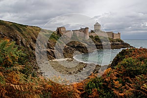 The famous medieval stone castle - fortress la Latte in the fall during a storm on the Celtic Sea in Normandy