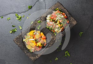 Famous mexican sauces salsas - pico de gallo, salsa bandera mexicana in stone mortars on gray slate background photo