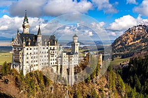 Famous Neuschwanstein Castle in the background Alps mountains and trees. Fussen, Bavaria, Germany