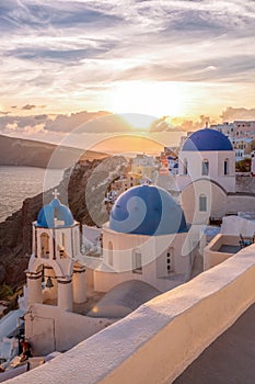 Oia village with churches against sunset on Santorini island in Greece
