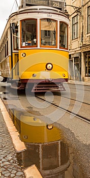 The famous, old, yellow trams travelling around the streets of Lisbon, Portugal