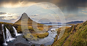 Famous picturesque Kirkjufell mountain and Kirkjufellsfoss waterfall next to Grundarfjordur at West Iceland autumn view