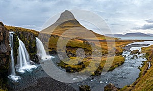 Famous picturesque Kirkjufell mountain and Kirkjufellsfoss waterfall next to GrundarfjÃ¶rÃ°ur at West Iceland autumn view