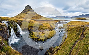 Famous picturesque Kirkjufell mountain and Kirkjufellsfoss waterfall next to GrundarfjÃ¶rÃ°ur at West Iceland autumn view