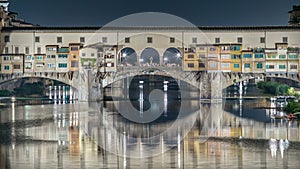 Famous Ponte Vecchio bridge timelapse over the Arno river in Florence, Italy, lit up at night