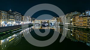 Famous Ponte Vecchio bridge timelapse over the Arno river in Florence, Italy, lit up at night