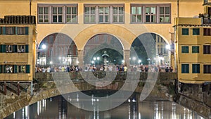 Famous Ponte Vecchio bridge timelapse over the Arno river in Florence, Italy, lit up at night