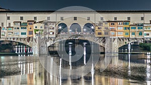 Famous Ponte Vecchio bridge timelapse over the Arno river in Florence, Italy, lit up at night