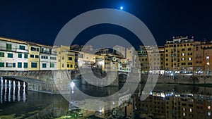 Famous Ponte Vecchio bridge timelapse over the Arno river in Florence, Italy, lit up at night