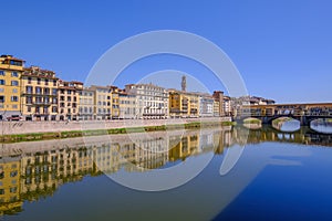 The famous Ponte Vecchio, the Old Bridge and city houses with reflections in the Arno River, Florence, Tuscany, Italy