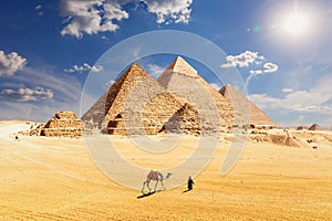 Famous Pyramids of Egypt and a bedouin with a camel, Giza, Cairo