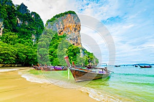 The famous Railay beach at Krabi, Thailand. Long tailed boats are prepared for passengers near limestone rock. Tropical paradise,