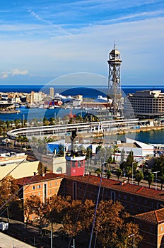 Famous red cablecar with people over the port in Barcelona. Transportation from Montjuic to the harbor of Barcelona.