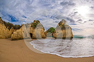 Famous rock formation with the cave on the beach of Tres Irmaos in Alvor, PortimÃÂ£o, Algarve, Portugal, Europe.