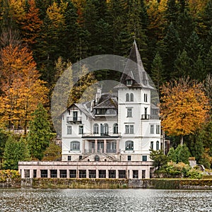 Famous schloss lake Grundlsee, Villa Castiglioni in colorful forest reflected in water, Dramatic autumn alpine scenery over lake