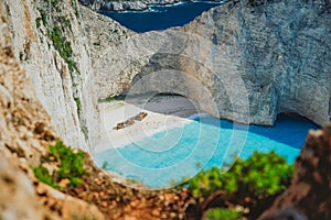 Famous shipwreck on Navagio beach with turquoise blue sea water surrounded by huge white cliffs. Famous landmark