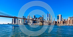 Famous Skyline of downtown New York City, Brooklin Bridge and Manhattan with skyscrapers illuminated over East River panorama. New