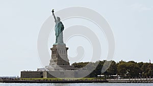 Famous Statue of Liberty national monument on Liberty Island in New York USA on a summer day, view from a tourist boat.