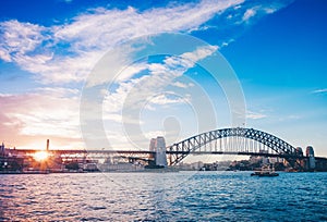 Famous sunset over Sydney Harbour Bridge. Stunning view of the waterfront near the Opera house.