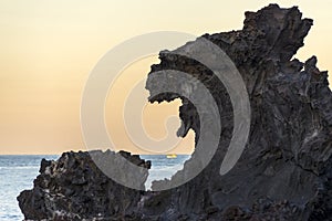 Famous tourist attraction in Jeju island of South Korea. View of Yongduam also known as dragon head rock during sunset.