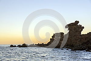 Famous tourist attraction in Jeju island of South Korea. View of Yongduam also known as dragon head rock during sunset.