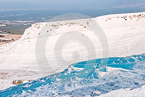 Famous travertines in Turkish resort of Pamukkale near the city of Denizli. White mineral rock outcrops and thermal water